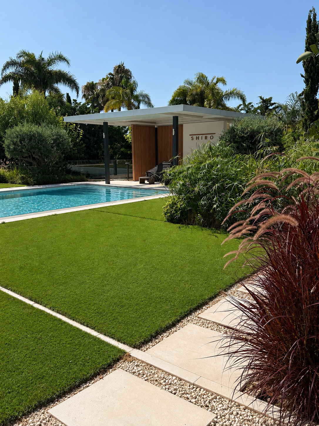 SuperGrass brand — premium artificial grass terrace with olive tree and sea view